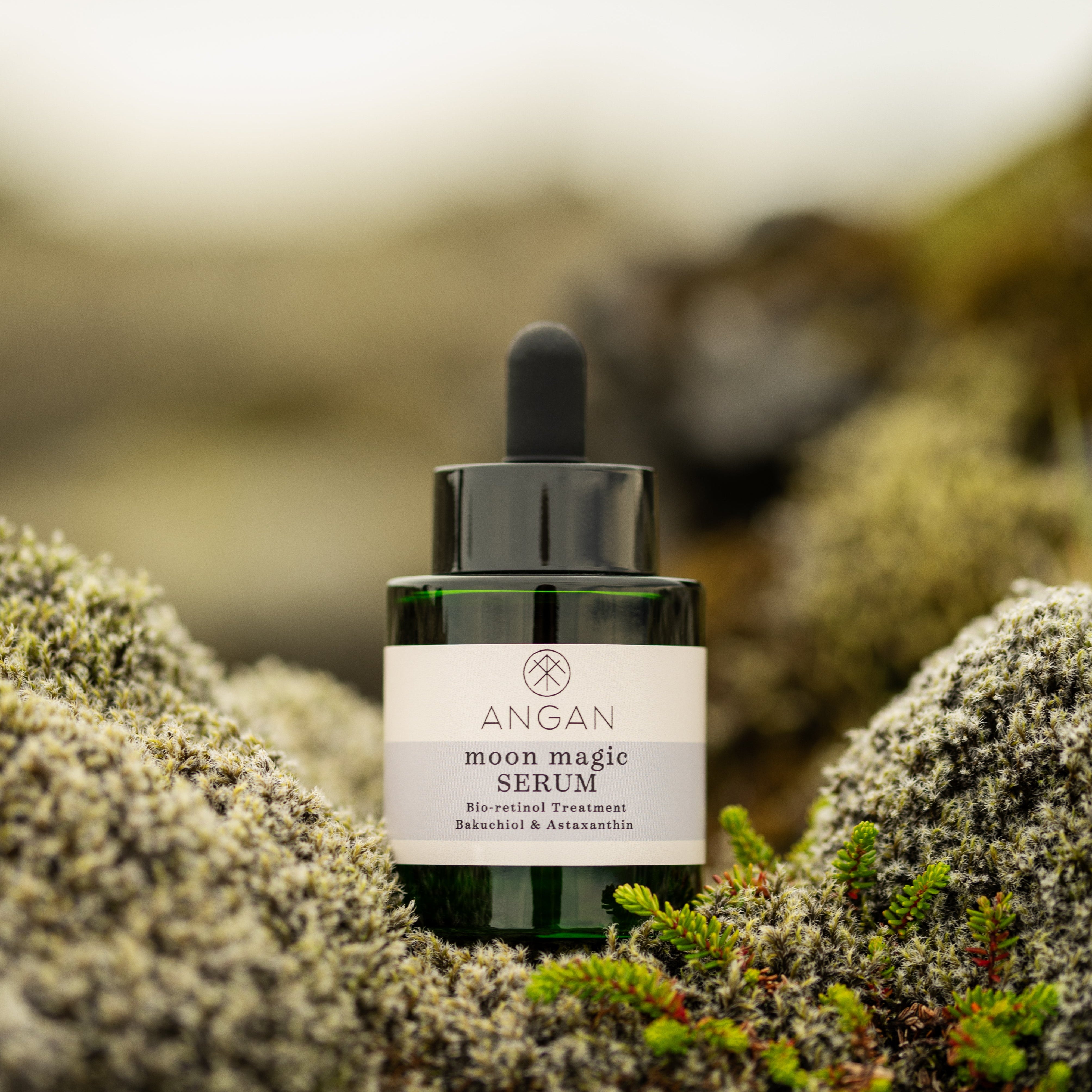 Bottle of ANGAN serum on a mossy background