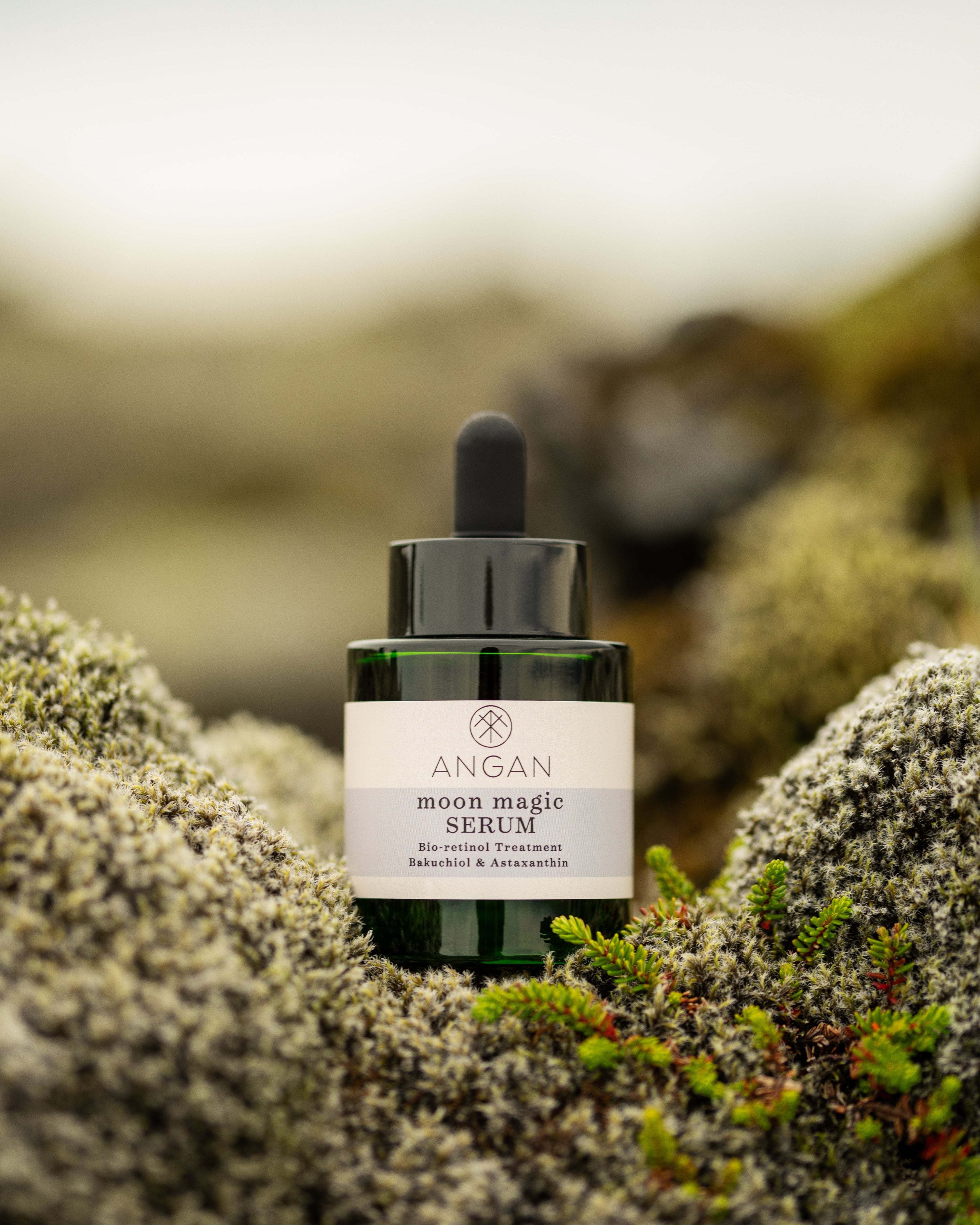 Bottle of ANGAN serum on a mossy background